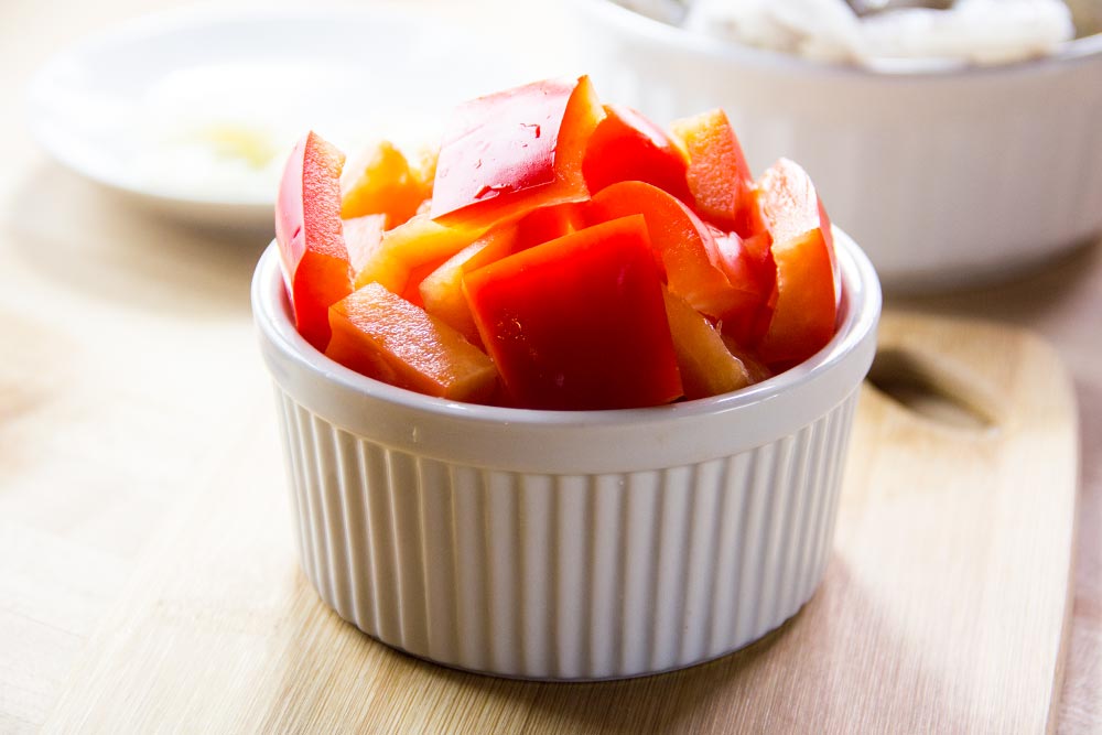 Chopped Red Bell Peppers in Bowl on Cutting Board