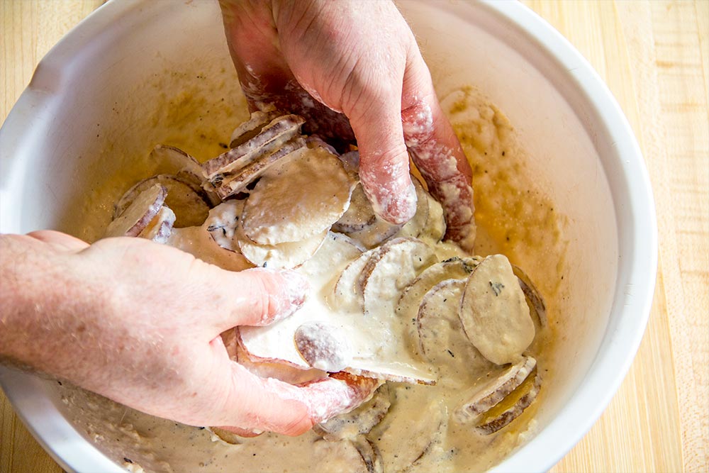 Mixing Sliced Potatoes with Cheese Mixture