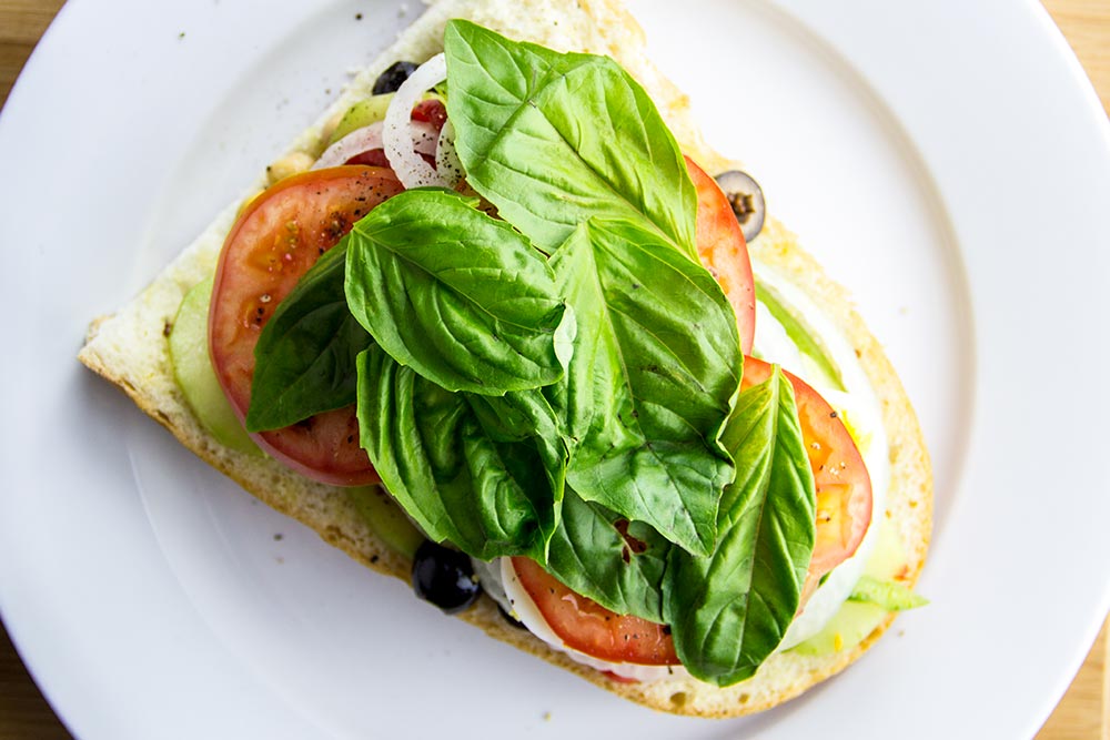 Adding Fresh Basil Leaves to Sandwich