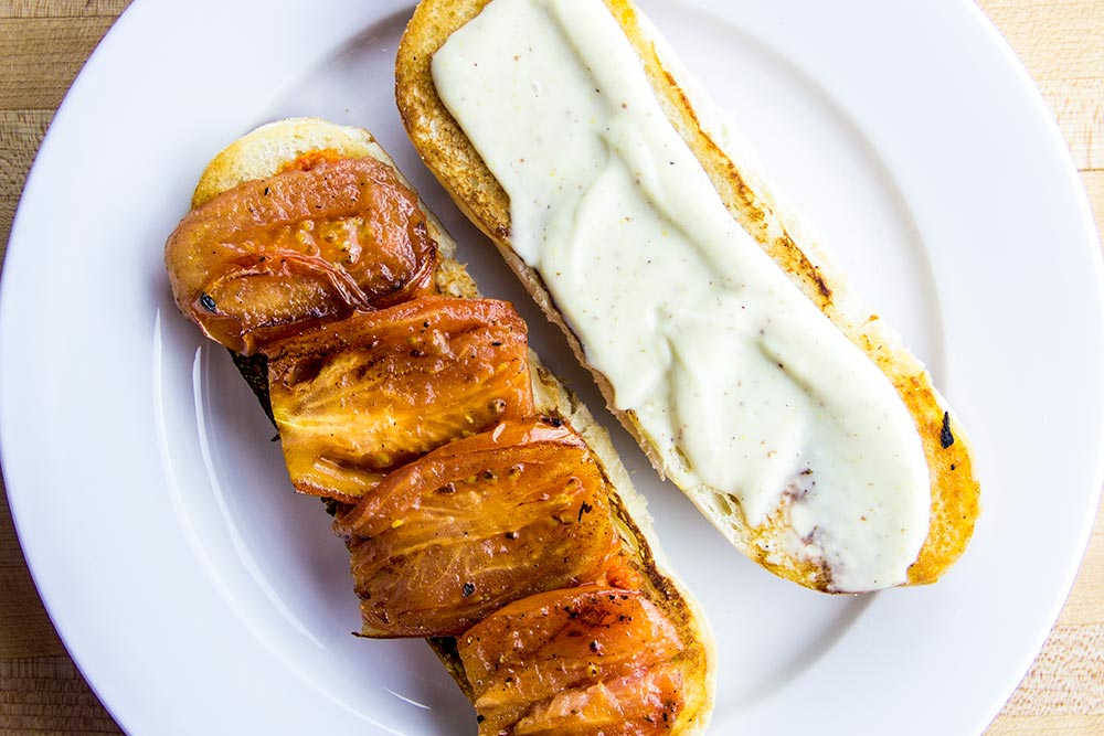 Adding Pan Fried Tomato Slices to Toasted Roll