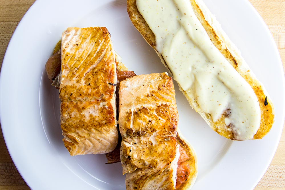 Adding Fried Salmon to Sandwich Roll