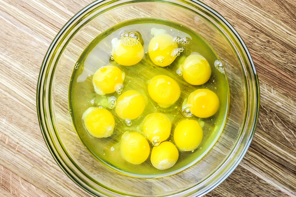 One Dozen Cracked Eggs in Bowl