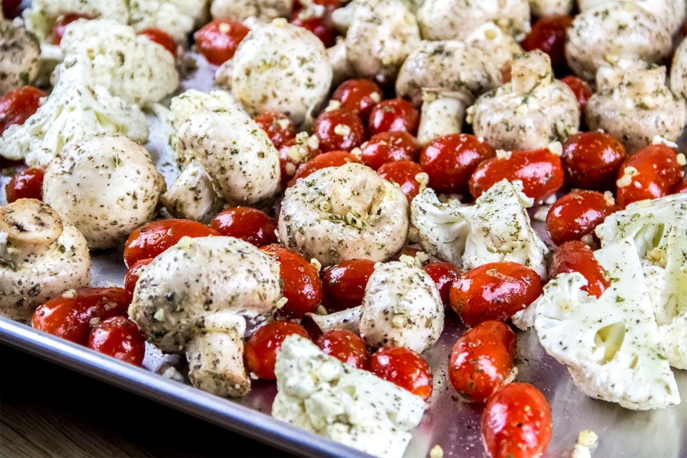 Raw Mushrooms, Tomatoes and Cauliflower on a Large Baking Sheet