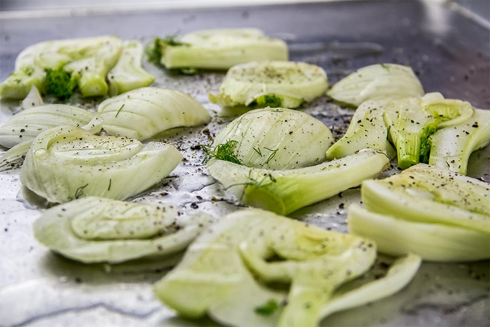Sliced Fennel with Salt and Pepper Sprinkled on It on a Baking Sheet