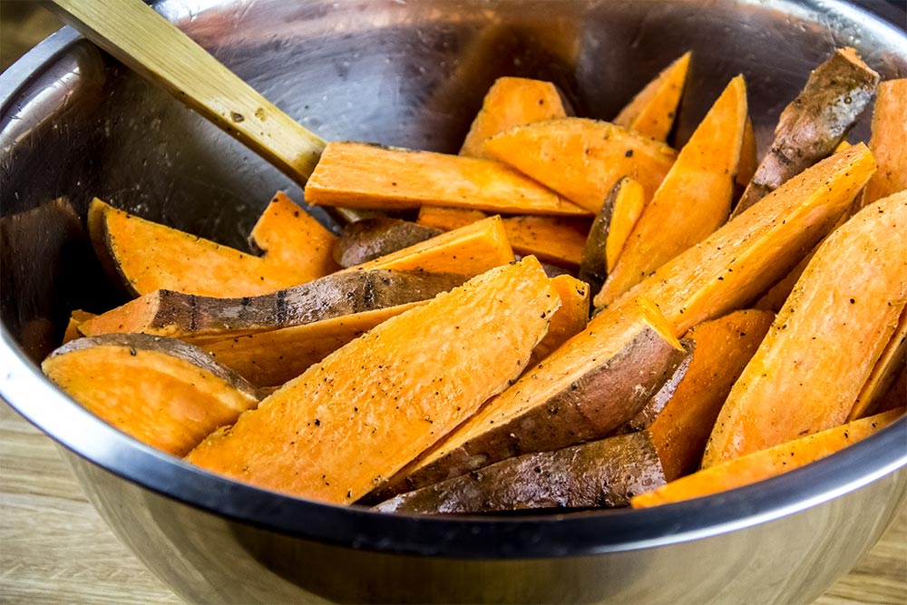 Oil Coated Sweet Potato Wedges in Large Bowl