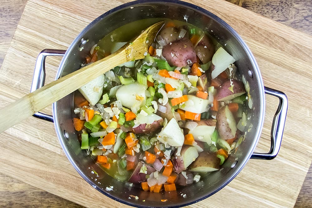 Adding Chopped Clams and Vegetable Broth to Saucepan