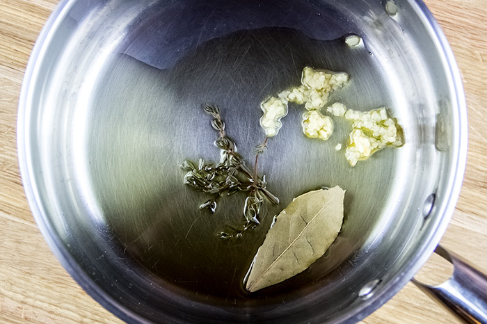 Simmering Garlic, Thyme and a Bay Leaf in Olive Oil
